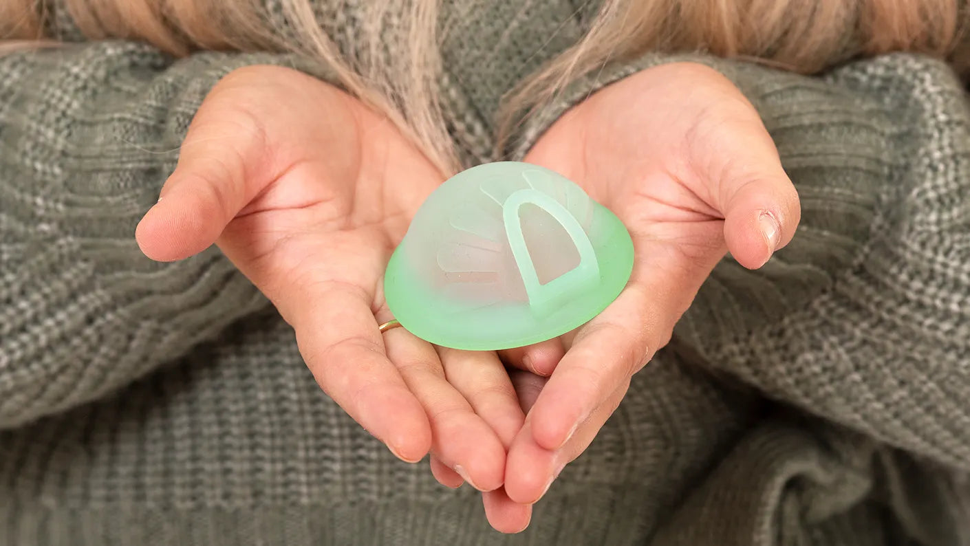 Discul menstrual reutilizabil Femi.Eko® cu inel de extracție, ținut cu grijă în mâini – protecție sigură, antibacteriană, fără sterilizare.